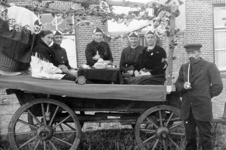 Feest Stavoren omstreeks 1933, ouderwetse kraamvisite
Van links naar rechts: frou I.de Haan, frou J. de Boer, frou P. Albertsma, frou Otter, frou Bakker, Ane Bajema (koetsier).
