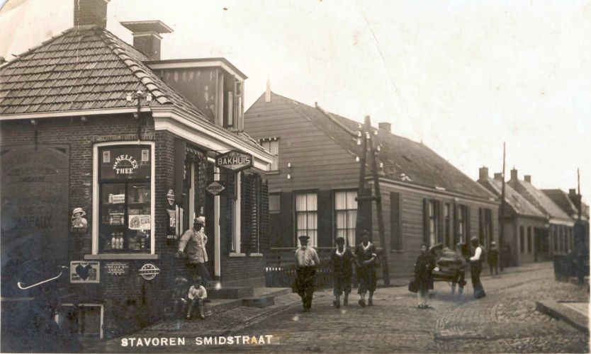 Smidstraat omstreeks 1930
Staand: Marten van Foeken, zittend: Hilda Koopman, Douwe van Foeken.
Lopend: Berend de Jong (?), 2 toeristen, Jeltje Kuperus, Sjoerd Kuperus.
